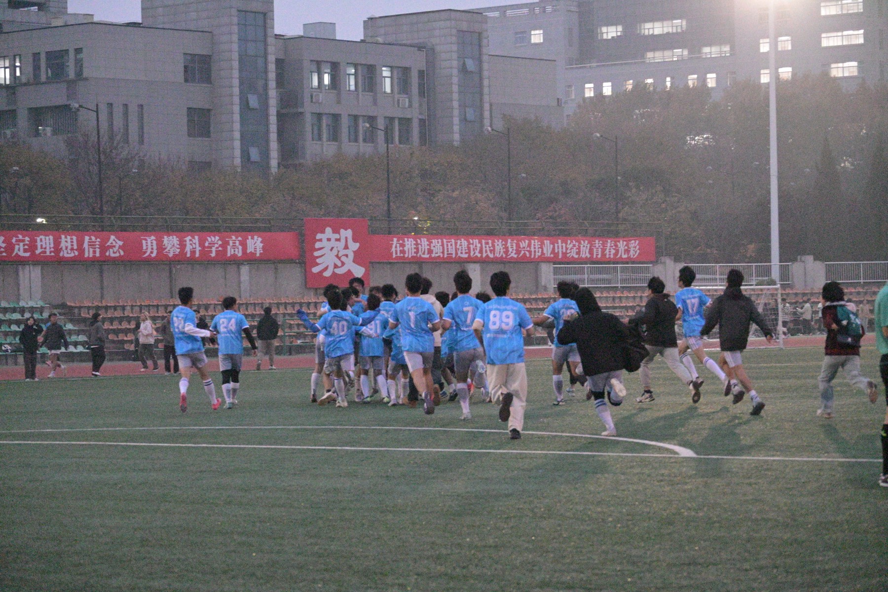 机电学院足球队队员在夜场共同跑向场边